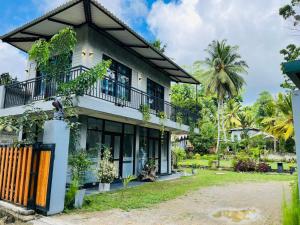 a house with a balcony and a yard at ORENDA ECO LODGE & SPA in Galle