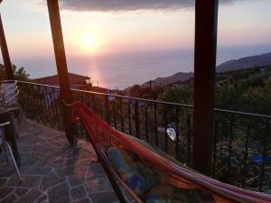 a hammock on a balcony with a view of the ocean at Guest House Pafili in Zagora
