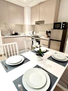 una cocina con una mesa con platos blancos. en OC Design at Yas Island - Deluxe Apartment en Abu Dabi