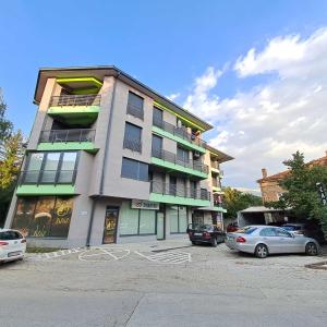 a tall building with cars parked in a parking lot at RINES Apartment in Ohrid