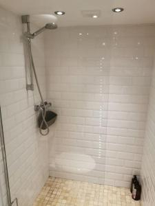 uma casa de banho com um chuveiro e piso em azulejo em Private garden apartment with secure parking em Southport