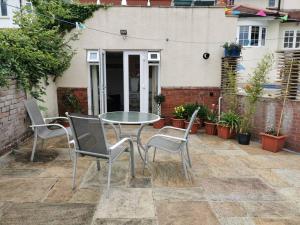 a patio with a table and chairs on a patio at Private garden apartment with secure parking in Southport