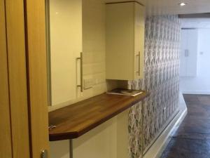 a kitchen with a counter top and a cabinet at Private garden apartment with secure parking in Southport
