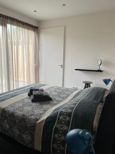 ein Schlafzimmer mit einem Bett, einem Stuhl und einem Fenster in der Unterkunft Huisje36 in Middelburg