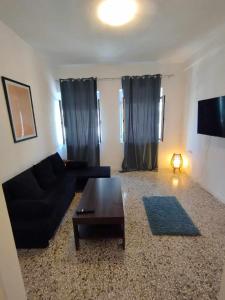 a living room with a black couch and a coffee table at Sunchaser Apartments in Igoumenitsa