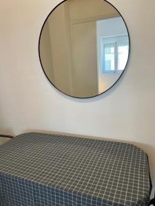 a bedroom with a mirror on the wall at Sunchaser Apartments in Igoumenitsa