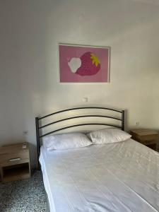a bed in a bedroom with an apple picture on the wall at Sunchaser Apartments in Igoumenitsa