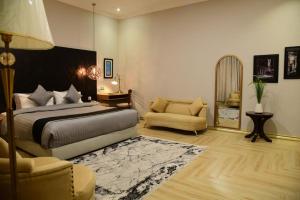 - une chambre avec un lit, un canapé et une chaise dans l'établissement Swan Suites, à Lahore