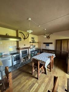 cocina con mesa y cocina con fogones en Rifugio Casa di Caccia en Noasca