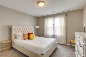 um quarto com uma grande cama branca com almofadas em Charming Omaha Vacation Rental 1 Mi to Downtown! em Omaha