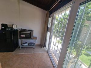 a living room with a microwave and a window at Elmy houses v3 / Clio in Rafina