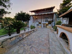 a house with a stone path in front of it at Elmy houses v3 / Clio in Rafina