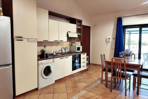 uma cozinha com uma mesa, um frigorífico e uma sala de jantar em Incantevole attico con grande terrazza em Anzio