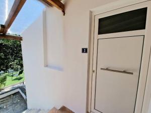 a white door with a sign on it next to a window at Elmy houses v3 / Clio in Rafina