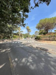 una calle vacía con árboles a un lado de la carretera en Studio Bord de Mer Boulouris à Saint Raphael en Saint-Raphaël