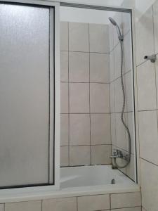 a shower in a bathroom with a glass door at Seaview Apartment in Tarrafal