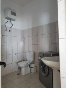 a bathroom with a toilet and a sink and a washing machine at Seaview Apartment in Tarrafal