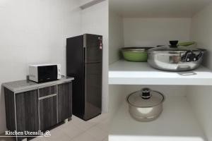 een keuken met een zwarte koelkast en een kom op een aanrecht bij Time Homestay (6-8pax) The Venus, Manjung/Sitiawan in Sitiawan