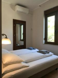 Duas camas num quarto branco com uma janela em Deviza Apartments em Budapeste