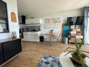 a living room with a table and a kitchen at Appartement Belles Vacances in Quiberon