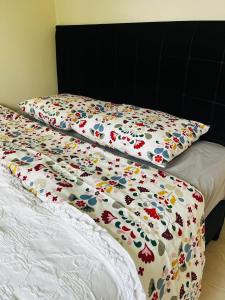 a bed with a comforter with flowers on it at Charming apartment in a red house in Stockholm in Stockholm