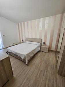 um quarto com uma cama e piso em madeira em Villa Center appartamenti nel verde in città em Campobasso