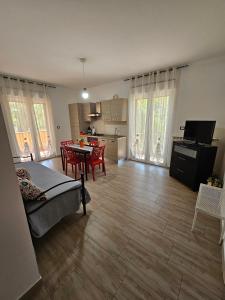 sala de estar amplia con mesa y cocina en Villa Center appartamenti nel verde in città, en Campobasso