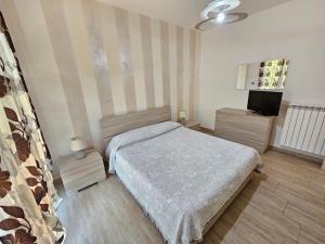 Dormitorio pequeño con cama y TV en Villa Center appartamenti nel verde in città, en Campobasso