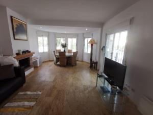 a living room with a television and a table with chairs at Luxury Paradise Beach Villa in Vera