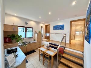 una cucina con scala, tavolo e sedie di Negrelli Appartement a Feldkirch