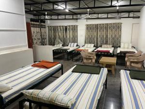 Cette chambre comprend plusieurs lits et chaises. dans l'établissement Yelagiri Naksha Tree Hotels, à Yelagiri