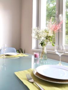 uma mesa azul com pratos e um vaso de flores em Cozy Apartment in Hannover Central em Hanôver