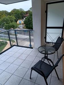 a chair on a balcony with a view of a street at BelMare 327 Aqua in Międzyzdroje