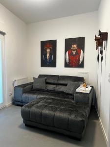 a living room with a couch and two paintings on the wall at Kurstadtapartment Baden-Baden in Baden-Baden