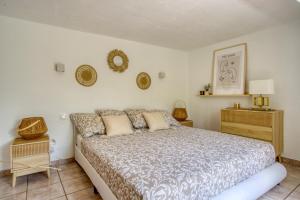 a bedroom with a large bed and a night stand at CHARMANT 2 PIECES DANS VILLA INDIVIDUELLE TERRASSES JARDIN in Carros