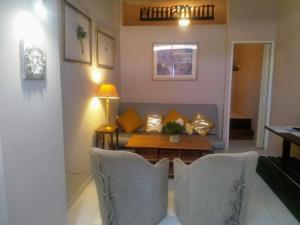 me gusta suite by the sea في أنافيسوس: غرفة معيشة مع أريكة وطاولة وكراسي