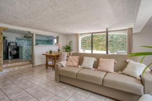 a living room with a couch and a table at CHARMANT 2 PIECES DANS VILLA INDIVIDUELLE TERRASSES JARDIN in Carros