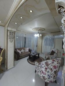 ein Wohnzimmer mit 2 Stühlen und einem Sofa in der Unterkunft الفيصل in Port Said