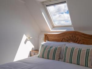 a bedroom with a bed with a window at Pass the Keys Tranquil cosy apartment in centre of Avening in Avening
