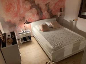 - une chambre avec un lit blanc et un mur rose dans l'établissement Vue imprenable sur mer, à Saint Pierre La Mer