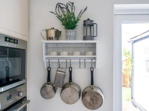 a kitchen with pots and pans hanging on a wall at Pass the Keys Bath Road Retreat 2 bedrooms with garden in Cheltenham
