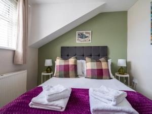 Un dormitorio con una cama grande con sábanas y almohadas púrpuras. en Pass the Keys Bath Road Retreat 2 bedrooms with garden, en Cheltenham