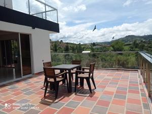 eine Terrasse mit einem Tisch und Stühlen auf dem Balkon in der Unterkunft Finca Villa Maru in El Peñol