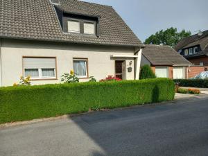 a house with a hedge in front of a street at Lütke-Dörhoff in Ennigerloh