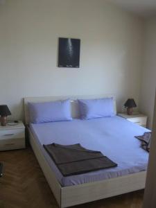 a bedroom with a white bed with blue pillows at Villa Curkovic in Ražanj
