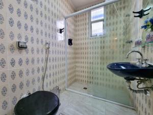 ein Bad mit einem Waschbecken und einem WC in der Unterkunft Apartamento em Pitangueiras! 70m da praia! Lindo e Aconchegante ! in Guarujá