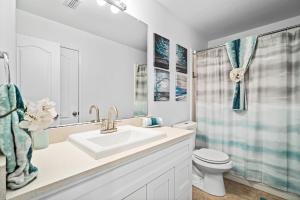 Luxury Family Retreat in Frisco, TX في فريسكو: حمام أبيض مع حوض ومرحاض