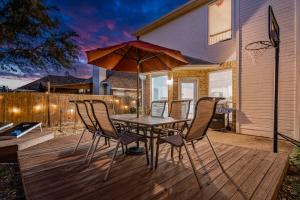 a patio with a table and chairs and an umbrella at Luxury Family Retreat in Frisco, TX in Frisco