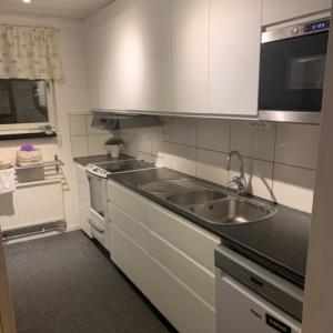 a small kitchen with a sink and a stove at Cozy Caravan With House Access! in Luleå +1 photo