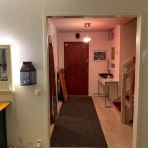 a hallway leading to a kitchen with a door and a table at Cozy Caravan With House Access! in Luleå